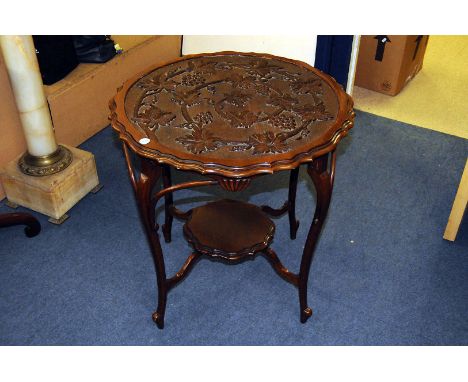 An Edwardian mahogany occasional table, the shaped circular top with moulded grape and vine design, on four supports united b
