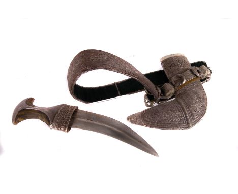 A white metal and horn handled jambiya, having decorative engraved scabbard, on white metal entwined belt
Scabbard - 24cm by 
