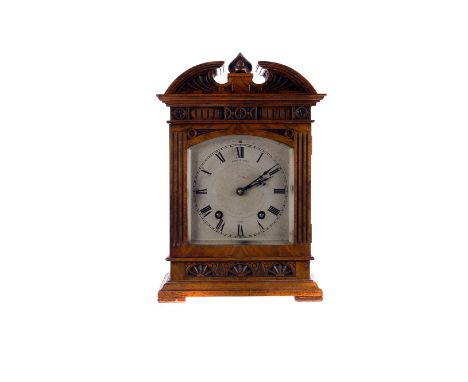 A mid 19th century walnut mantle clock,  with architectural cornice and carved frame, the silvered dial signed 'Reid & Sons' 