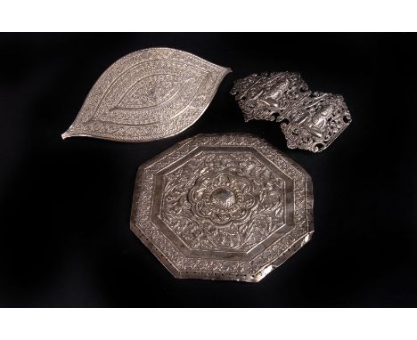 An Indian white metal buckle,  of elliptical form, decorated with raised bands of alternating designs, 15cm long, together wi
