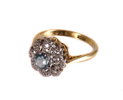 A modern 18ct gold and gem set cluster dress ring, with a central light blue stone, probably a zircon, surrounded by eight cu