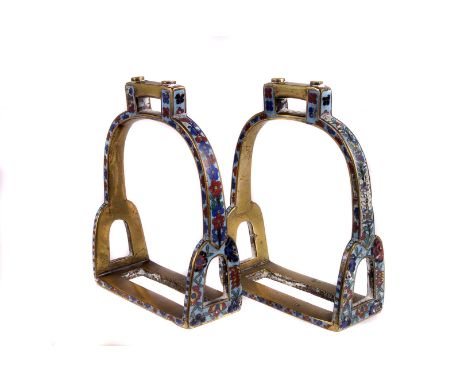 A pair of 19th century Chinese brass and cloisonné enamel stirrups,  the polychrome borders decorated with flowers, each 14.5