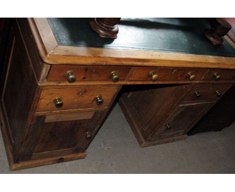 A 20th century stripped pine pedestal desk, with green inset upper, with three drawers to each pedestal, with single drawer a