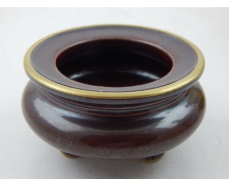 A Chinese lustered inkstand, with gilt rim, raised on tripod feet, bears seal mark to base. D. 9cm