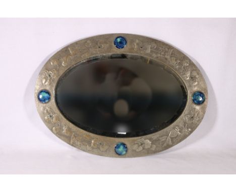Arts and Crafts hammered pewter oval wall mirror decorated in repousse with goldfish and flowerheads and four Ruskin style en