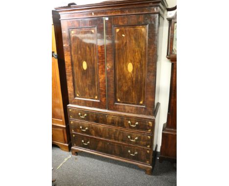 Georgian mahogany and inlaid linen press, the moulded cornice above two panel cupboard doors over three graduated long drawer