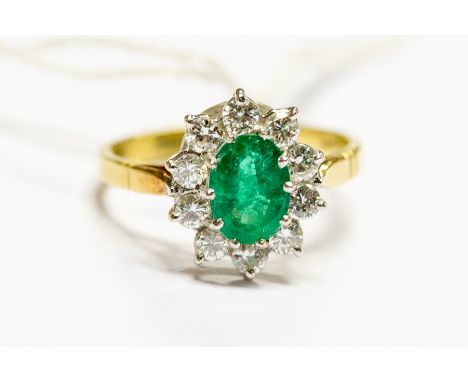 An 18ct yellow gold, emerald and diamond cluster ring, the oval cut emerald approx 8.24mm x 6mm x 3.77mm, ten diamonds of app