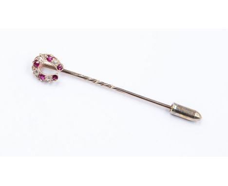 A ruby and diamond horseshoe stick pin, assessed as approx 9ct, total gross weight approx 1.7gms
