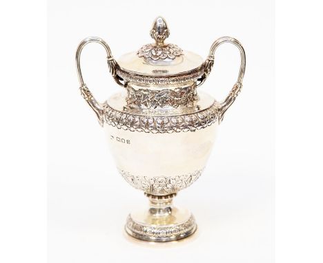 A George V silver small twin handled cup and cover, the body with borders of stylized foliate decoration, the cover with acor