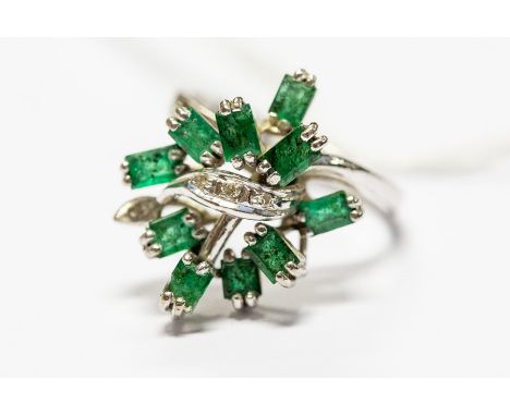 An 18k white gold diamond and emerald dress ring