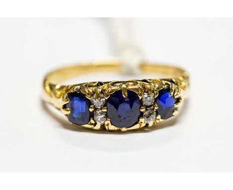 An 18ct gold ring, set with three blue sapphires with diamond set accents, size R, total gross weight approx. 3.7gms&nbsp;