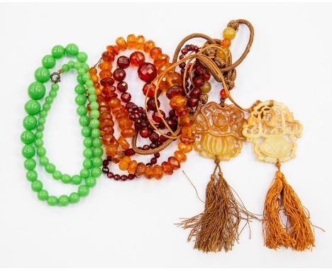 A brown jade pierced and carved pendant, approx 19gms; and another similar; a graduated faceted amber bead necklace, approx 4