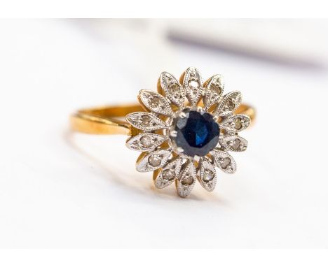 A sapphire and diamond flower head cluster ring, set to the centre with a round sapphire approx 4mm, with petal decoration se