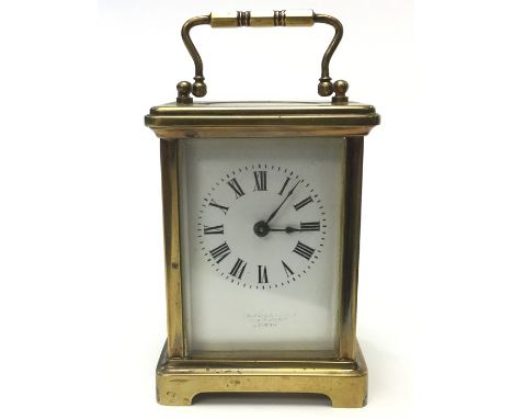 A Brass Carriage Clock with white enamel dial and Roman numerals. London makers mark. Height including handle extended upward