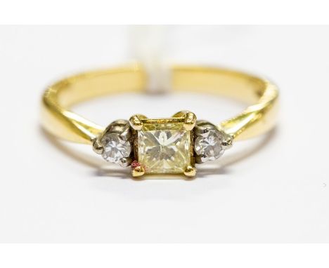 An 18ct gold and diamond three stone ring, central set princess cut 0.45ct of fancy light yellow colour, flanked by two brill