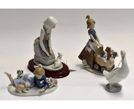Two Lladro figures of young girls with puppies along with two Nao figures