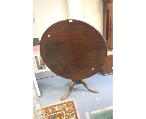 A George III mahogany tilt top table, circa 1800, circular top above a turned column on tripod form cabriole supports.