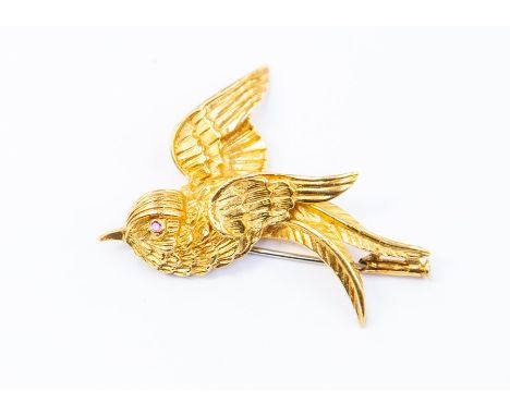 A Continental yellow gold swallow brooch with round cut ruby eye, tests as approx 14ct, approx 7.7gs