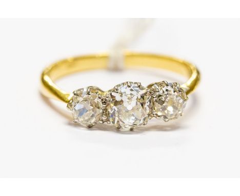 An 18ct gold and diamond three stone ring, central old cut approx 0.75ct, flanked by two smaller diamonds, size P, approx 3.2