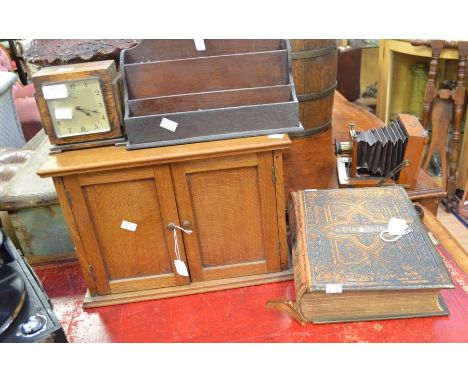 A 19th Century family Bible with two brass clasps, one loose, on oak smokers cabinet, a wooden stationery rack and an Art Dec