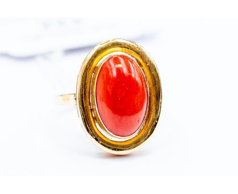 A coral set dress ring, set with an oval coral, size approx. 15mm x10mm, rub-over set with a rounded border&nbsp; size Q1/2, 