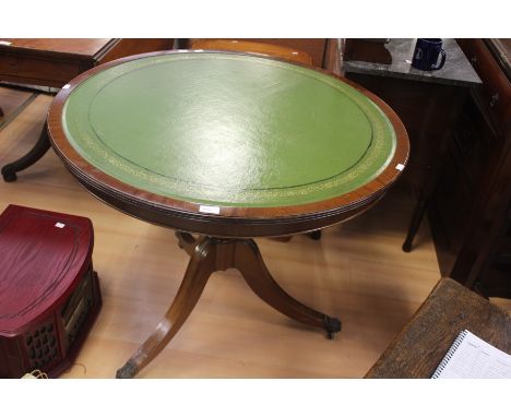 A 19th Century style mahogany circular library table, green leather inlay top on a turned column, raised on tripod saber supp