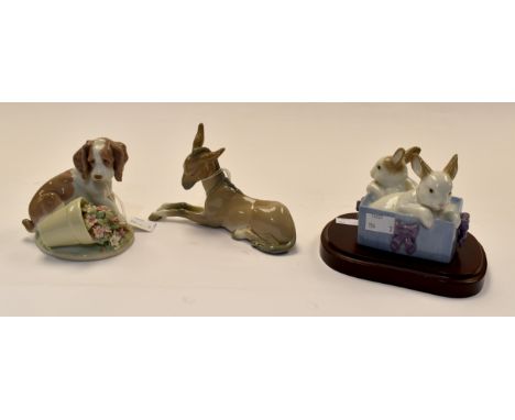 Lladro: A spaniel puppy- knocked over flowers, a Lladro donkey and a Nao pair of rabbits- presentation box- on plinth