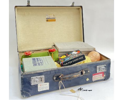 A vintage leather travelling case containing various vintage children's toys and games including doll, toy soldiers, games, p