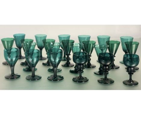 A matched suite of twenty-three 19th century emerald green glass wines of various shapes, comprising: seven with trumpet bowl
