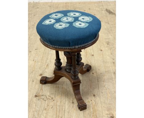 An Edwardian walnut revolving adjustable piano stool, raised on centre column with turned tripod columns to side, on square m