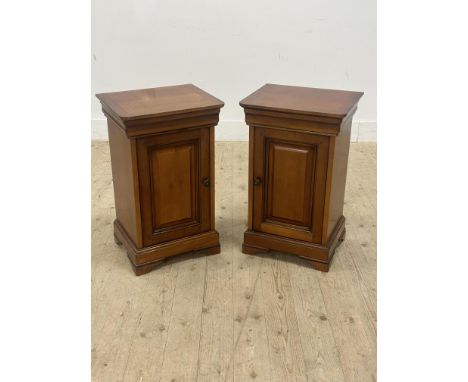 A pair of Continental Normandy style cherrywood bedside cabinets, with rectangular tops, inset panel doors which enclosed a s