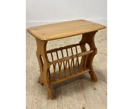 An Ercol light elm side table with shaped rectangular top with magazine rack base raised on pierced shaped end supports&nbsp;