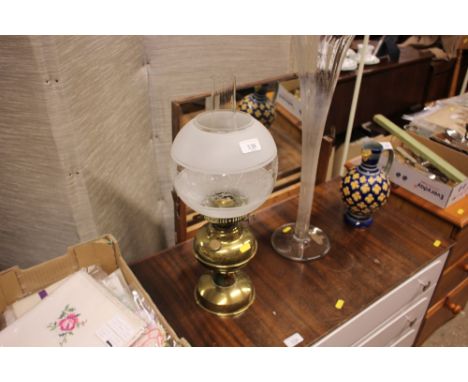 A brass oil lamp with etched glass shade 