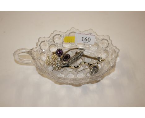 A glass dish containing a lady's cocktail watch; silver dress ring; ear-rings and a brooch in the form of a snake