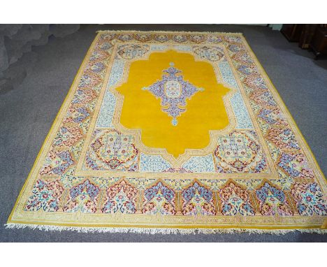 A modern machine made Persian carpet, with central medallion over a mustard yellow ground, 503cm x 356cm