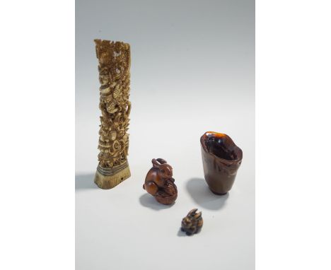 A miniature Chinese horn 'libation cup', 5.5cm high, two Japanese carved wood netsuke of rabbits, and an Indonesian carved bo