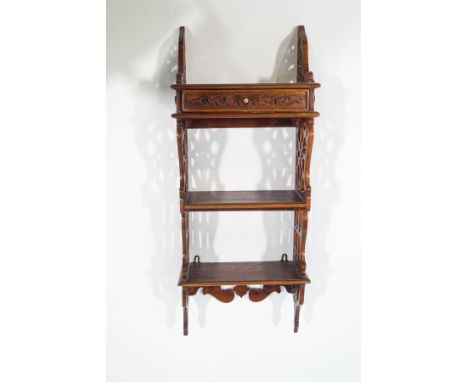 A reproduction mahogany wall shelf, in the Chippendale style, with single drawer below three shelves, 85cm high