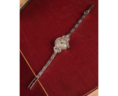 A diamond encrusted ribbon bows cocktail watch, silver dial, Arabic numerals, tied ribbon bows case pave encrusted with old a