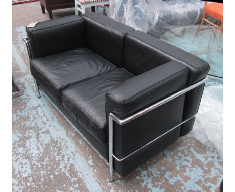 SOFA, by Le Corbusier, model 'LC2', black leather with tubular metal frame, 69cm D x 69cm H x 130cm L. 