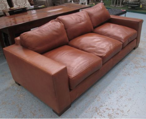 SOFA, three seater, in tanned leather on block supports, 216cm L (with faults)