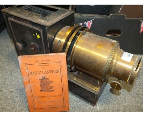 AN ANTIQUE MAGIC LANTERN WITH BRASS LENSE AND AN INSTRUCTION BOOKLET