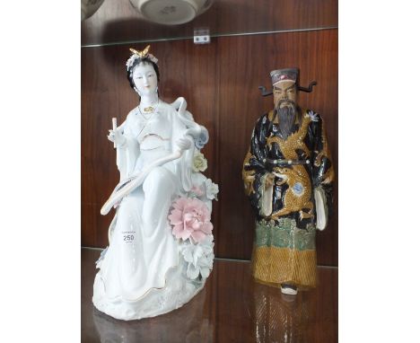 A LARGE ORIENTAL STYLE CERAMIC ARTIST FIGURE TOGETHER WITH A FIGURE OF A MAN