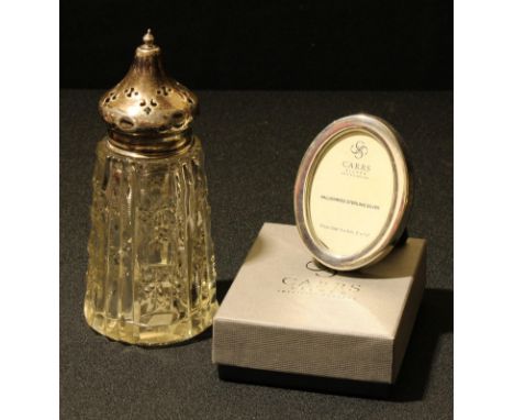 An Elizabeth II silver easel photograph frame, Carrs, Sheffield 2017; a George V silver mounted clear glass sugar caster, Bir