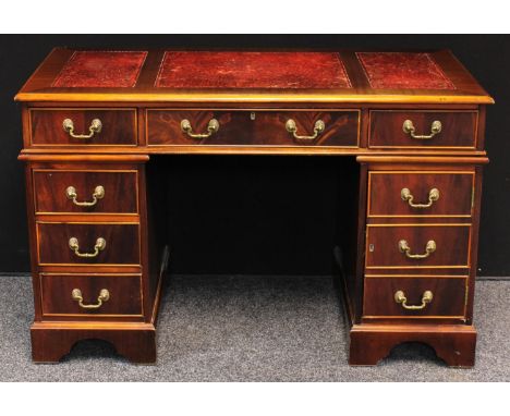 A George III style twin pedestal desk, rectangular top with three inset writing surface above three frieze drawers, three fur