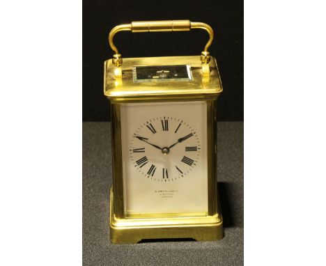 A 20th century brass carriage clock, the white dial with Roman numerals, inscribed S Smith and Sons Ltd, Strand, London. beve