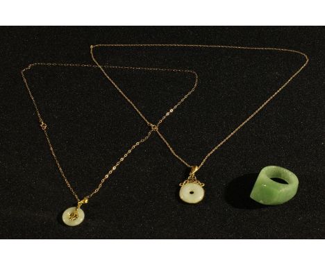 A gold mounted jade pendant; another similar; a jade ring (3) 