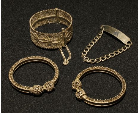 A silver identity bracelet, hallmarked; a white metal filigree bangle; two bracelets (4) 