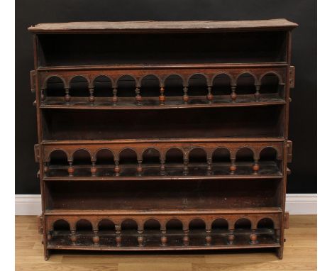 An 18th century Continental country house spice or plate rack, of peg-and-joint construction, shallow moulded top above three