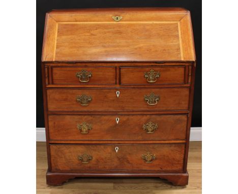 A George III mahogany bureau, fall front enclosing a baize lined writing surface, a small door, drawers and pigeonholes, abov