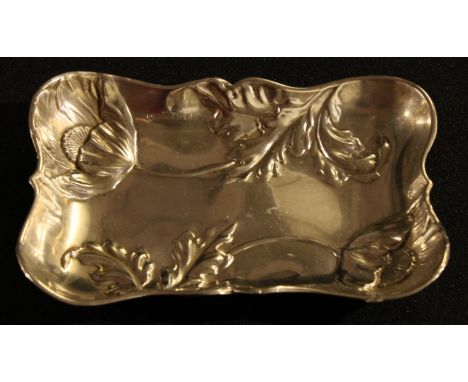 A silver rounded rectangular trinket dish, embossed with poppies, 12cm wide, marks rubbed, c.1900, 66.8g 